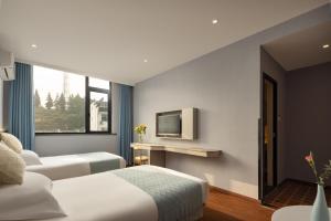 Postel nebo postele na pokoji v ubytování Anlan Hotel Shangrao Wuyuan Cultural Plaza + 23 fotografií