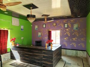 a bar in a restaurant with purple and green walls at Desert Life safari camp in Sām