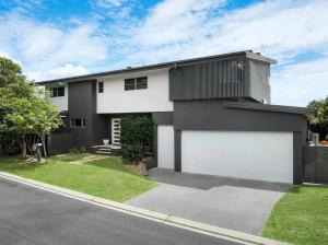 een huis met twee garagedeuren in een straat bij Zinc Casuarina in Casuarina