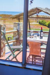 una ventana con vistas a una mesa y sillas en Hermosa Casa OlaSurf Punta de Lobos & Marbox 7 en Pichilemu