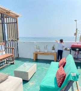 kobieta stojąca na balkonie z kanapą w obiekcie Habitación y terraza con vista al mar w mieście Lima