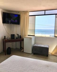 una camera con un letto, una scrivania e una grande finestra di Habitación y terraza con vista al mar a Lima