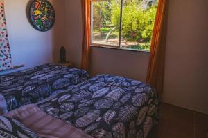 1 dormitorio con cama y ventana en Hermosa Casa OlaSurf Punta de Lobos & Marbox 7 en Pichilemu