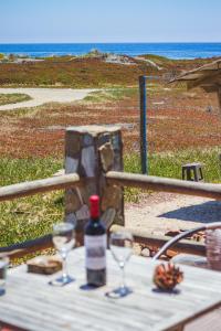 una botella de vino sentada en una mesa con dos copas en Hermosa Casa OlaSurf Punta de Lobos & Marbox 7 en Pichilemu