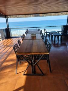 East West Beach Resorts في فاركَالا: طاولة وكراسي خشبية طويلة على سفينة سياحية