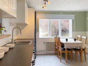 a kitchen with a table and chairs and a window at 8 person holiday home in ANNEBY-By Traum in Aneby