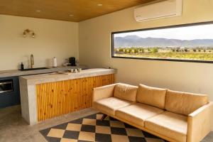 ein Wohnzimmer mit Sofa und großem Fenster in der Unterkunft MiLu in El Porvenir
