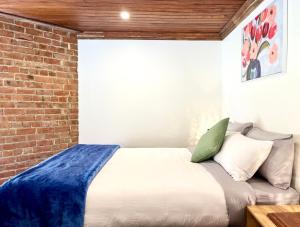 a bed in a room with a brick wall at Opoho Heritage Guest Suite in Dunedin