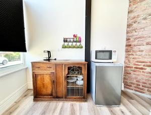 una cucina con mobile in legno e forno a microonde di Opoho Heritage Guest Suite a Dunedin