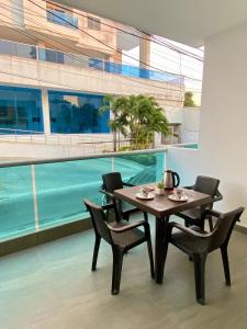 uma sala de jantar com mesa e cadeiras e uma piscina em Guakmaya hostel em Cartagena de Indias