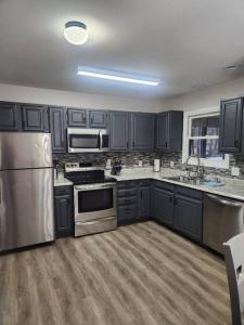 una cocina con armarios negros y electrodomésticos de acero inoxidable en Poconos Retreat, en Bushkill