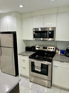 a kitchen with a stainless steel stove and a microwave at Lovely lake view apartment downtown Calgary one bedroom fully furnished in Calgary
