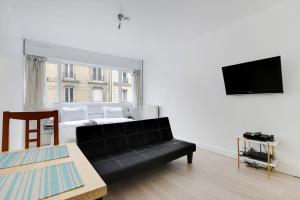 巴黎的住宿－Appartement Alesia，客厅配有黑色沙发和床。