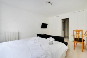 巴黎的住宿－Appartement Alesia，一张白色的床,上面有两只填充的动物