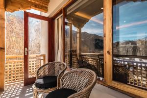 a balcony with chairs and a view of the mountains at The Legacy Alchi in Leh