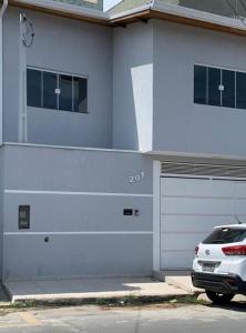 um carro branco estacionado em frente a um prédio em CASA FAMILIAR “SANTA PAZ” 2 em Aparecida