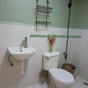 a white bathroom with a toilet and a sink at Save room in Manila +8 photos