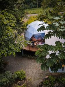 a tent with a person in it in a forest at Bitzu Dome-Bijagua Riverside Glamping in Bijagua