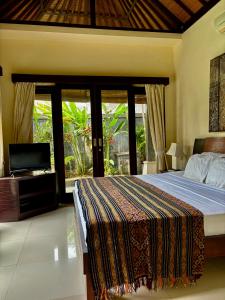 a bedroom with a bed and a television in it at Villa Buddha Umalas in Kerobokan