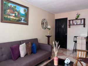 uma sala de estar com um sofá e uma pintura na parede em Casa Cacique Liberia em Liberia