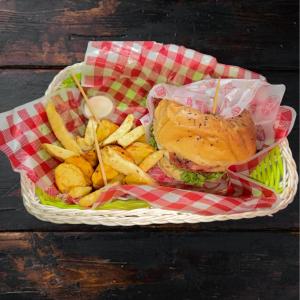 um cesto de comida com uma sanduíche e batatas fritas em Hostal Piedra del Ocaso em Manizales