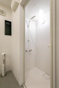 a white bathroom with a shower and a television at City Center Villas ゲストハウス3.5 in Hijiyamachō