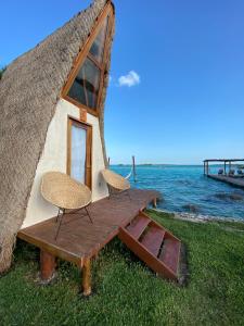 une maison avec une table et deux chaises en face de l'océan dans l'établissement Hotel CasaBakal - A pie de Laguna - Bacalar, à Bacalar