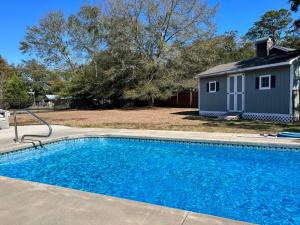 a swimming pool in front of a house at Murrels Inlet House Private Heated Saltwater Pool in Myrtle Beach