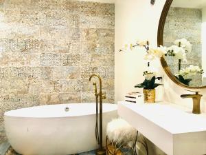 ein Bad mit einer Badewanne und einem Spiegel in der Unterkunft Luxury City Tiny House in Denver