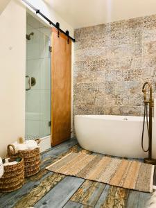 a bath tub in a bathroom with a brick wall at Luxury City Tiny House in Denver