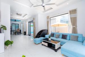 a living room with a blue couch and a table at B2.11 Hoàng My Villa in Vung Tau