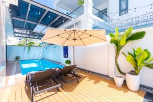 a patio with a table and chairs and an umbrella at B2.11 Hoàng My Villa in Vung Tau