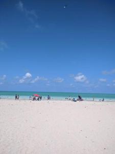 a group of people standing on a beach at Casa aconchegante próxima a Praia de Jaguaribe in Itamaracá