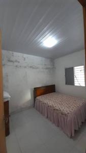 sypialnia z łóżkiem w białym pokoju w obiekcie Casa aconchegante próxima a Praia de Jaguaribe w mieście Itamaracá
