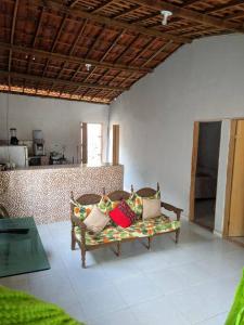 a couch with pillows on it in a room at Casa aconchegante próxima a Praia de Jaguaribe in Itamaracá