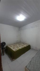 um quarto com uma cama e uma cadeira num quarto em Casa aconchegante próxima a Praia de Jaguaribe em Itamaracá