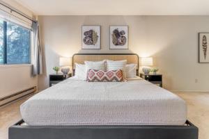 a bedroom with a large bed with two tables at Tranquil Apt 2 King Suites Pet Friendly near DT Bellevue in Bellevue