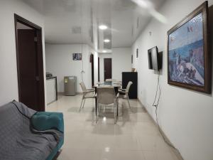 a living room with a table and chairs and a tv at Hospedaje casa Blanca, la mejor opción en Guaviare in San José del Guaviare