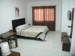 Schlafzimmer mit einem Bett, einem Schreibtisch und einem Fenster in der Unterkunft Salvador Dali Apartments in Amman