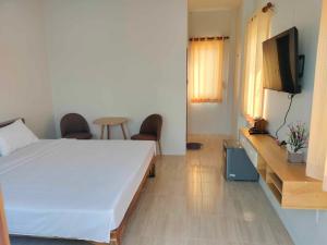 a bedroom with a bed and a television in it at กุหลาบแก้ว รีสอร์ท in Ban Mae Lai