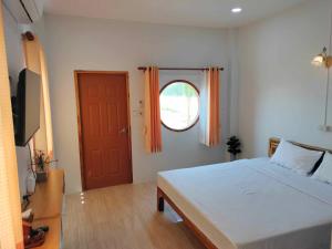 1 dormitorio con 1 cama grande y puerta roja en กุหลาบแก้ว รีสอร์ท en Ban Mae Lai