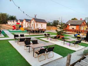 a park with tables and chairs and a playground at กุหลาบแก้ว รีสอร์ท in Ban Mae Lai