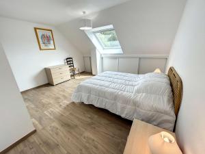 ein Schlafzimmer mit einem Bett und einem Dachfenster in der Unterkunft Maison Jullouville, 5 pièces, 7 personnes - FR-1-361-511 in Jullouville-les-Pins