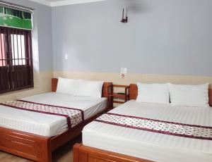 Un pat sau paturi într-o cameră la Khách sạn Ánh Đông