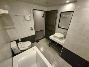 a bathroom with a toilet and a sink at No. 25 Hotel Myeongji Oceanc City Business in Busan +14 photos