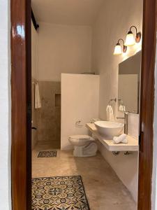 a bathroom with a sink and a toilet at CASA XTABENTUN in Mérida