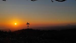 een kruis op een heuvel bij zonsondergang bij Río Celeste Nature View in Upala