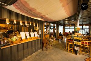 a restaurant with a counter and people sitting at tables at GISY Lake House in Sóc Sơn