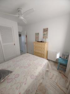 ein Schlafzimmer mit einem Bett und einer Kommode darin in der Unterkunft Apartamento con inmejorables vistas de la Barrosa in Chiclana de la Frontera