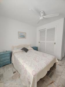 ein Schlafzimmer mit einem Bett und einem Deckenventilator in der Unterkunft Apartamento con inmejorables vistas de la Barrosa in Chiclana de la Frontera